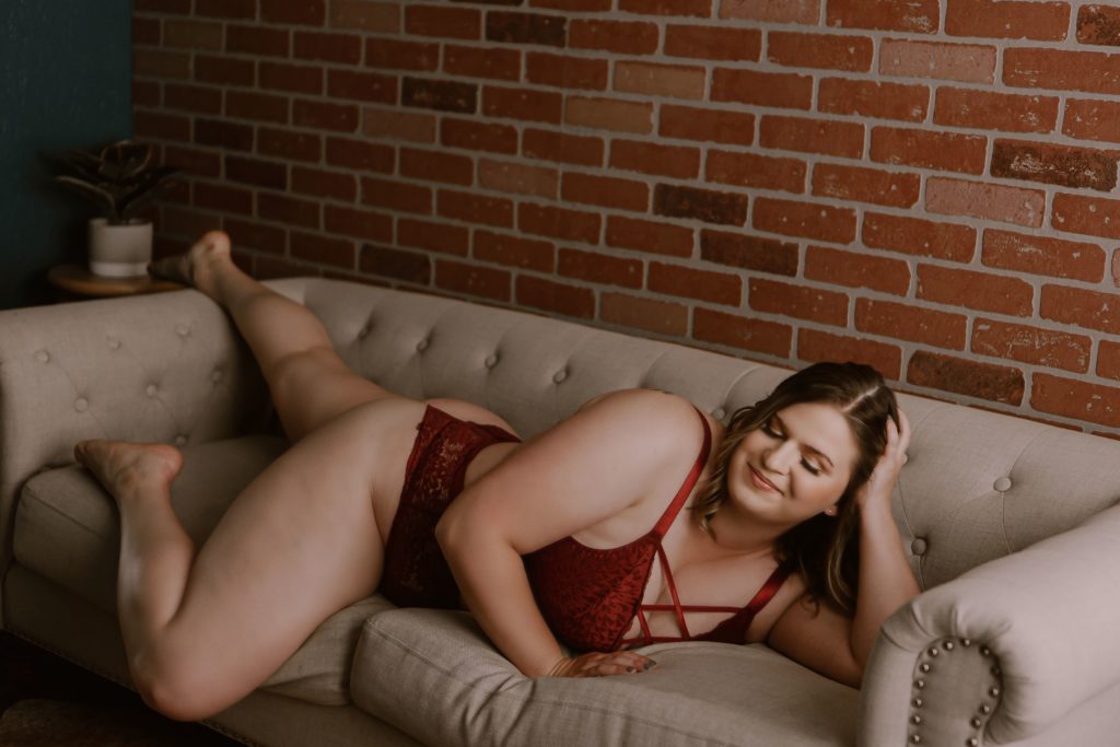 st. louis boudoir photographer woman in red laying on couch