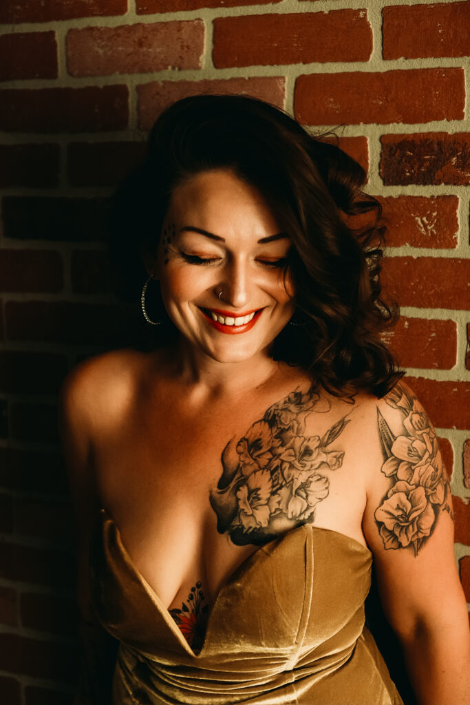 gold velvet bodysuit lingerie / brunette woman leaning against a brick wall laughing / spray tans for boudoir / photo by boudoir by vanessa summers of st. louis, mo. see more at www.stlboudoirphotographer.com/blog